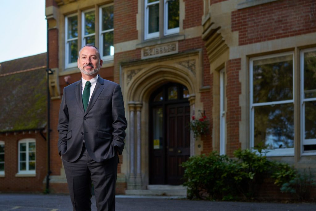 principle of the school, standing in front of school