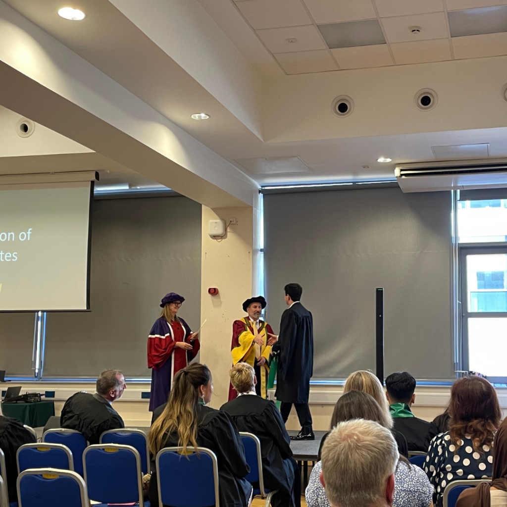 A picture of a student collecting their graduation certificate