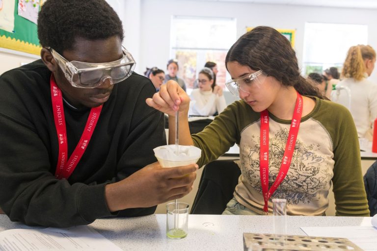 A picture of two students doing a Science experiment.